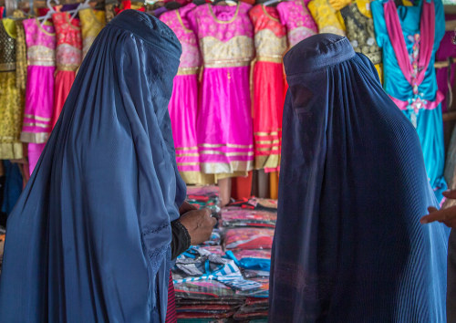 Women wearing burkas in the market buying clothes, Badakhshan province, Ishkashim, Afghanistan. Take