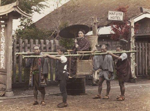 Men carrying woman palanquin in front of Hafuya Hotel, Hakone, Japan.  Hand-colored photo, Japa