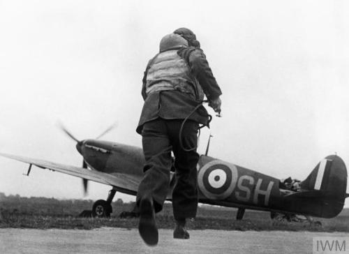 Pilots of &lsquo;B&rsquo; Flight, No. 32 Squadron, relax on the grass at RAFHawkinge in front of a H