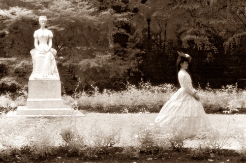 thepompandcircumstance: A woman out for a walk with a statue of Kaiserin Sissi nearby.