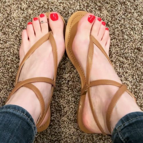 Strappy thong sandals on pretty feet.