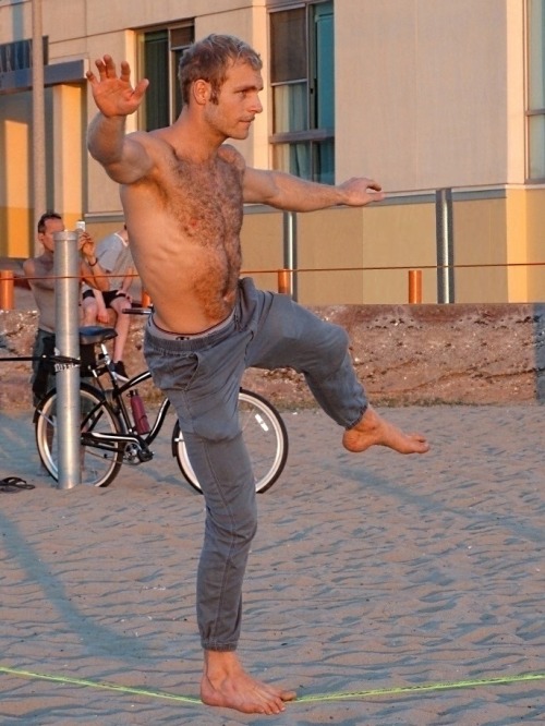 musclsvg:  Lean and muscular, a beach stud shows off a feral, furred physique as he works the slack 