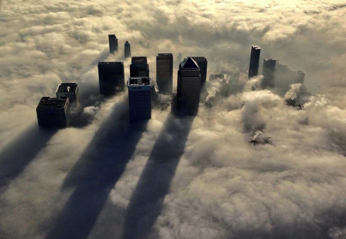 awkwardsituationist:  chicago fog The Canary Wharf business district of east London taken from the Metropolitan Police helicopter is seen during a foggy morning in this photograph received via the Metropolitan Police in London on December 11, 2013. —