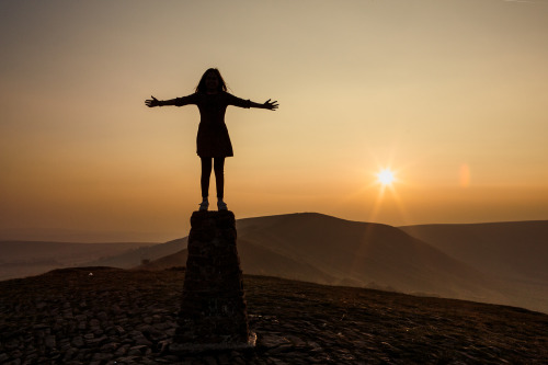 My daughter stood on top of  a trig point on Mam Tor in the Peak District, Derbyshire