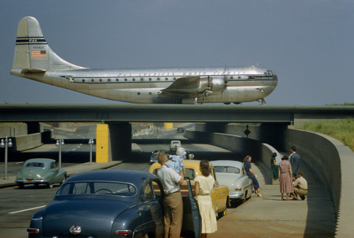 Sightseers park to watch a Stratocruiser taxi across an underpass in Queens, New York, March 1951.Ph