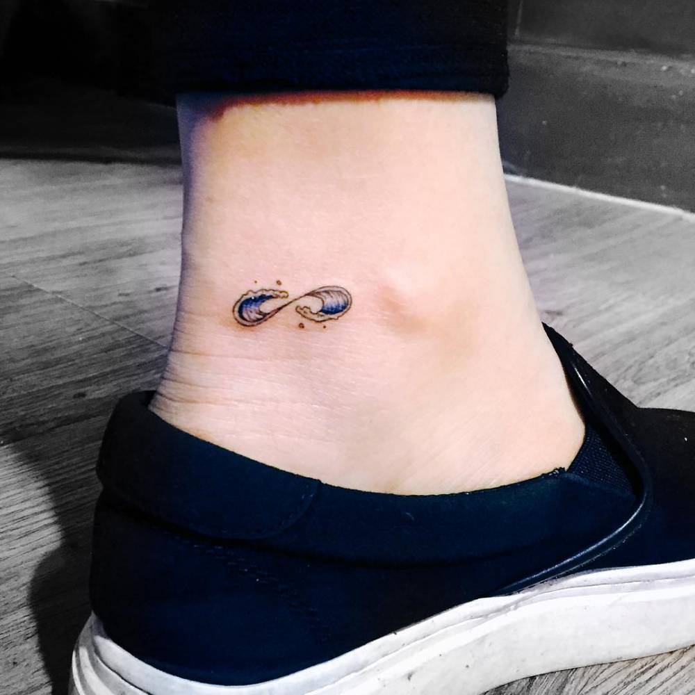 Minimalist sun and wave tattoo on the ankle