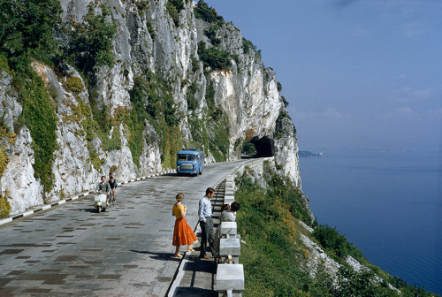 natgeofound: Motorists pass people on a scenic road atop a cliff overlooking a bay near Trieste, Ita