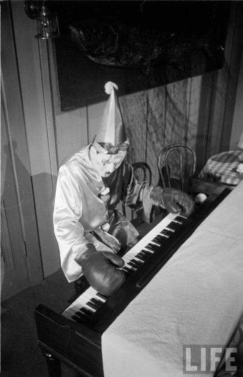 Clown playing the keyboard while wearing boxing gloves(Loomis Dean. 1952)