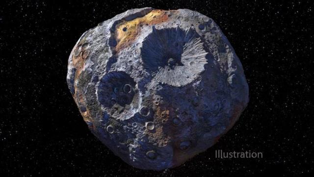 ALT text: Artist’s concept of the asteroid Psyche. The darkness of space takes up the entire background with small twinkly stars. Two large craters are at the center of the asteroid. The asteroid is mostly silvery with a few spots of copper on the surface. The word "Illustration" is printed at the bottom to the right of the asteroid. Credit: NASA/JPL-Caltech/ASU/Peter Rubin