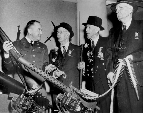 Civil War veterans being shown World War II rifles and machine guns on Veterans Day at the Minnesota