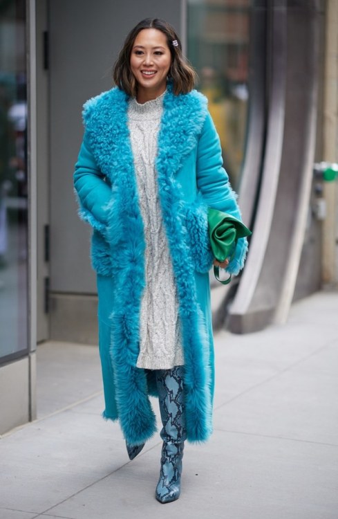 Aimee Song walks outside of the Tibi show wearing a suede trench coat during New York Fashion Week o