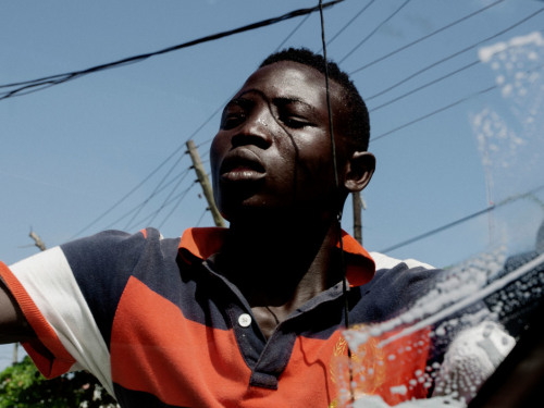 manufactoriel: A boy washing the car glass,  Lagos (2013) by Alex Majoli