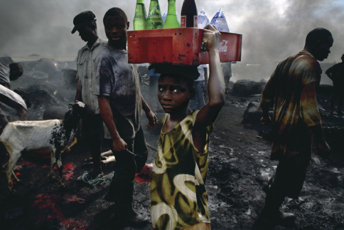 Ed Kashi. “A boy sells drinks to the workers at the Trans Amadi Slaughter, the largest abattoir in t