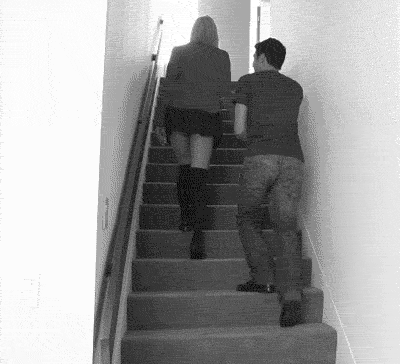 A couple has a little urge in the stairs.