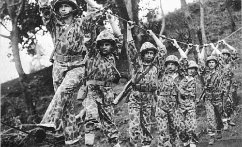 Marine Corps Raiders crossing a rope bridge, World War II.