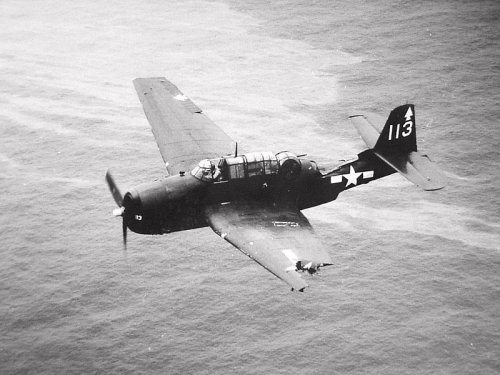 history-museum:TBM Avenger torpedo bomber from aircraft carrier USS Bennington in flight, with a dam