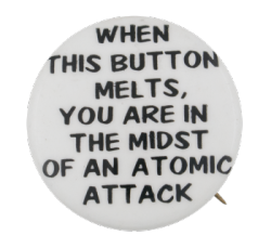 a white pin with black text that reads 'WHEN THIS BUTTON MELTS, YOU ARE IN THE MIDST OF AN ATOMIC ATTACK'