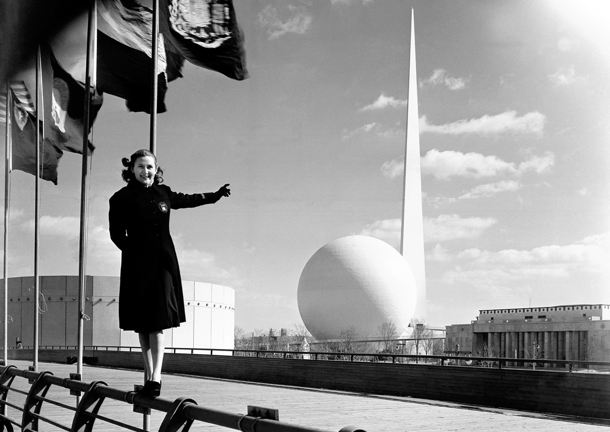 From The 1939 New York World’s Fair, one of 42 photos. Rosalie Fairbanks, a guide to the New York World’s Fair, points to the theme of the exposition – the Trylon and Perisphere – in New York on February 22, 1939, after the entire sheath of...