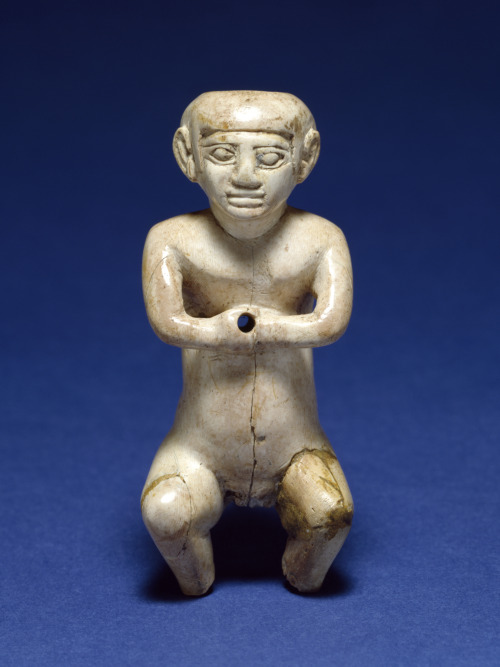 Ancient Egyptian statuette of a male dwarf, carved from hippopotamus ivory.  Artist unknown; ca