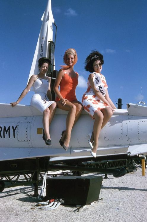 atomic-flash: Miss Miami 1963, and two cohorts, strike a pose while sitting on a Nike Hercules nucle