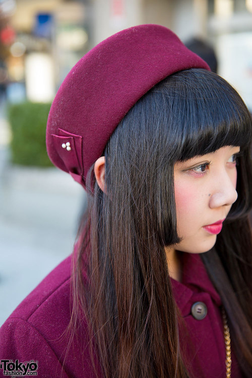 21-year-old Maho on the street in Harajuku wearing a maroon pillbox hat and matching resale maxi-coa