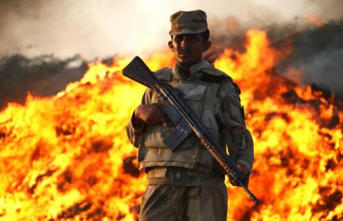 A member of the Pakistani security forces stands guard during the incineration of seized illegal dru