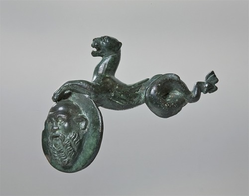 Decorative piece in the shape of a sea-panther-monster holding a shield with a Silenus maskImage fro