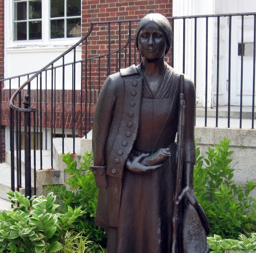 Statue of Deborah Sampson holding her musket and powder horn while clothed in a Continental Army uni