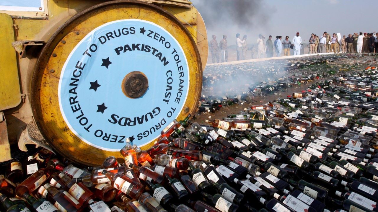 PROHIBIDO. Una apisonadora conducida por guardias costeros destruye botellas de licor el lunes 13 de noviembre de 2017, en Karachi, Pakistán. Los guardacostas paquistaníes destruyeron una gran cantidad de licor ilegal y drogas que han sido...