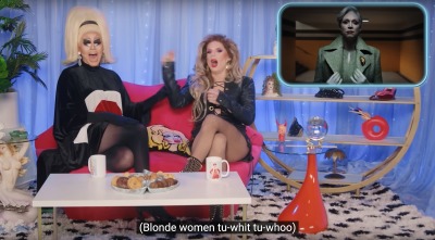 Drag queens Trixie and Katya sit on a pink couch on a colorful Netflix set. Superimposed in the corner is a clip from Wednesday. Caption reads: Blonde women tu-whit tu-whoo