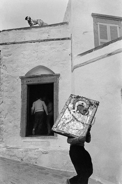 gemsofgreece: Man carrying a larger than himself icon of Virgin Mary, a dog on the roof… the 