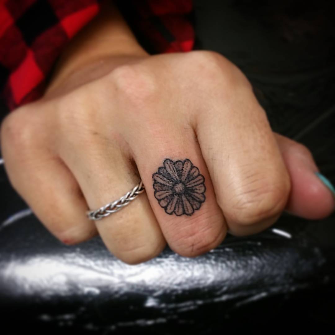 Minimalist daisy flower tattoo on the