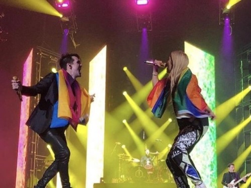 ilovemygaydad:wallflowerlisa: Hayley Kiyoko and Brendon Urie with their flags while singing Girls/Gi