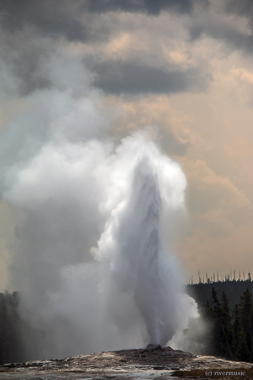 Old Faithful erupts into a smokey stormy sky: Yellowstone National Park, Wyomingriverwindphotography