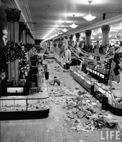 historicaltimes:  Macy’s department store employee cleaning up piles of debris after the Christmas shopping rush, 1948  Photographer: Nina Leen. via reddit