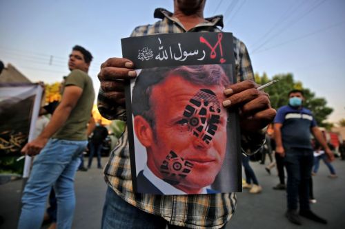 Iraqi men protest against French President Emmanuel Macron in front of the French embassy in Baghdad