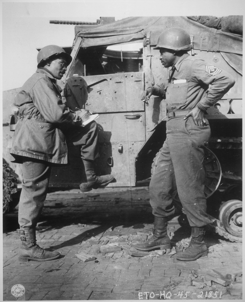 War Correspondent Ted Stanford of The Pittsburgh Courier interviews 1st Sgt. Morris O. Harris, a tan