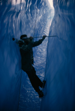 natgeofound:  Wedged in a crevasse, Tylor Kittredge drills holes for marker pegs in an Alaskan glacier, February 1967.Photograph by Christopher Knight, National Geographic 