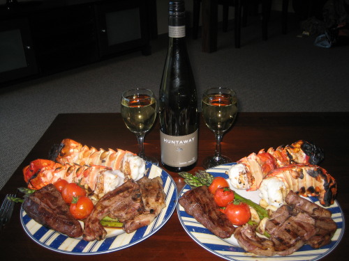 “Surf and Turf, New Zealand Style. Barbecued Rock Lobster, Venison, Lamb Chops, Tomatoes, Aspa