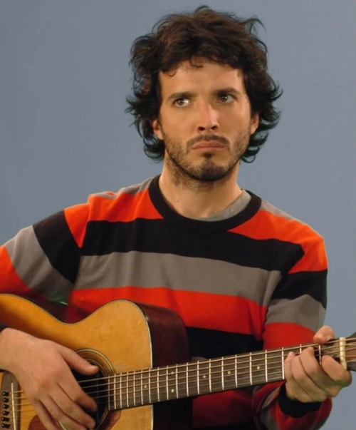 Brett McKenzie from Flight of the Conchords holding a guitar