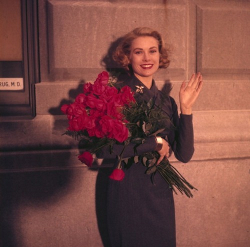 graceandfamily:  Grace Kelly Leaving New York in April 1956 — Grace Kelly Leaving New York. En 1956, à New-York, portrait en extérieur de Grace KELLY, en robe, tenant un bouquet de roses. 