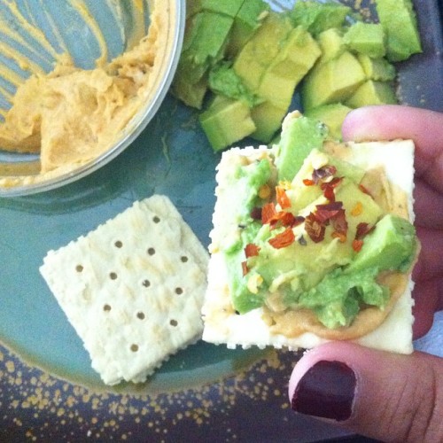 Snack time! Sundried tomato and basil hommus, avocado, and red pepper flakes on saltines. #yum #avoc