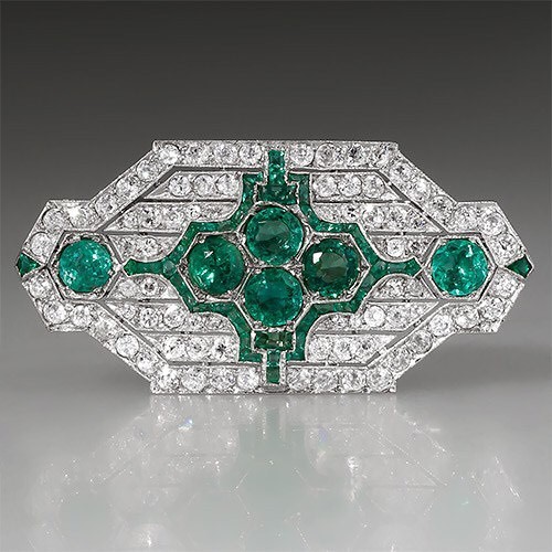 This Art Deco brooch features natural emeralds and diamonds set in platinum. Available from EraGem.