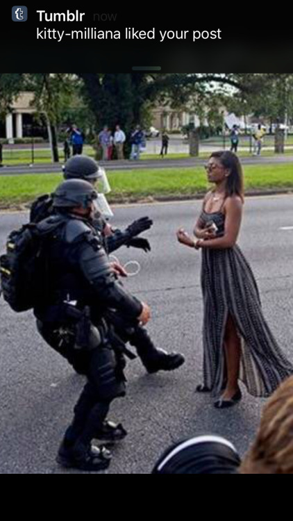 pleasetrysomethingelse:  e4knee:  frontpagewoman:  This picture is breaking Twitter: Woman confronts police at BLM protest in Baton Rouge, Louisiana. Who is she?✊🏾   This picture is so striking. She is like an ancient statue brought to life to defend