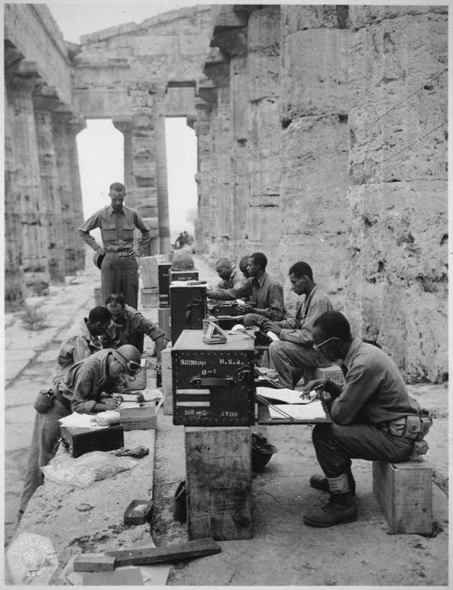 historicaltimes:A company of men has set up its office between the columns of an ancient Greek templ