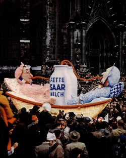 In the parade of satirical floats, most of them mocking politics, Konrad Adenauer and Pierre Mendès France are gulping for the most Rich Saar Milk, 1955.