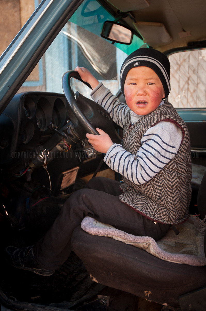 A young Kyrgyz boy sits in the driver’s seat of his father’s Lada in Nura, Kyrgyzstan.
An earthquake on October 6, 2008 hit the village, resulting in at least 75 deaths and leveling about 100 buildings. That means this boy was probably just a year or...