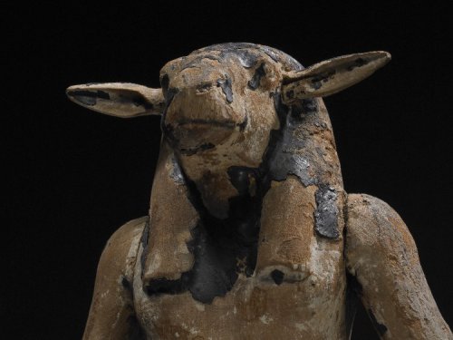 virtual-artifacts:Wooden figure of an enthroned ram-headed god with arms outstretched; overlaid with