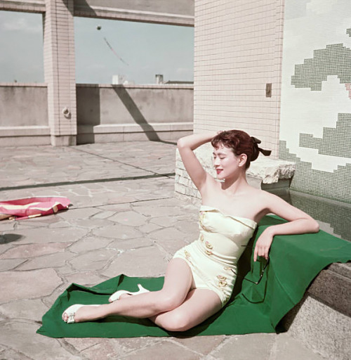 s-h-o-w-a: Japanese actress Mie Kitahara posing in a swimsuit sitting on a beach towel, Japan, late 