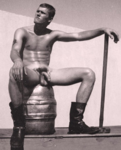 vintagemusclemen:  Tonight we look at some physique model photos with puzzling props and contexts.  Here we see a young man deep in philosophical thought … sitting on a beer keg with a sledge hammer and some hefty boots.